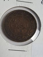 Obverse side of 1899 Canada One Cent Large Penny coin showing date and denomination with leaf border design in circulated grade with patina.