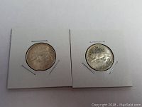 Photo shows two 1967 Canada silver centennial quarters in white 2x2 coin holders, front and reverse visible with some patina.