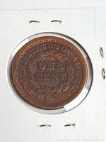 Reverse side showing the wreath surrounding the inscription ONE CENT with UNITED STATES OF AMERICA around the edges on a 1854 large cent penny.