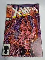Full cover photo of the 1986 Marvel Comics X-Men issue 205 showing character entangled in cables with Marvel 25th Anniversary logo.