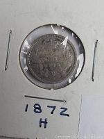 Front side of the 1872 Canada silver five cent coin in protective holder, showing crown above date with wreath surrounding