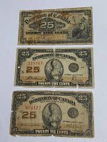Three Dominion of Canada 25 Cents Shinplaster notes arranged vertically, visible date July 17, 1923 on two notes and varying wear on all.