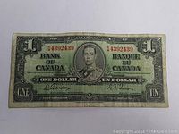 Front side of 1937 Canada one dollar bill showing King George VI portrait, serial number in red ink, and bilingual text.