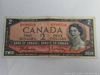 Front view of the 1954 Canadian two dollar banknote showing Queen Elizabeth II portrait and serial number.