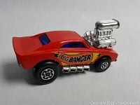 Front left side view of red 1972 Matchbox Big Banger toy car showing chrome engine and side exhausts.