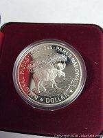 Close-up photo of the silver commemorative coin featuring a moose and National Parks inscription dated 1885-1985.