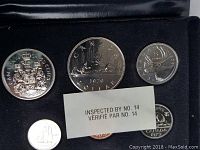 Close-up showing several coins from the 1979 Canadian set including the 50 cents with coat of arms, 1 dollar coin, 25 cents caribou, and 1 cent coin.