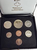 Seven 1976 Canadian coins displayed in black foam insert inside burgundy presentation box