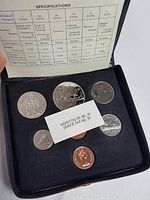 Top view of mint coin set inside black foam holder including all coins and coin specifications document.