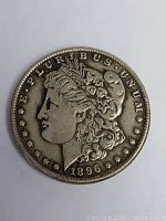 Obverse side of 1896 Morgan silver dollar showing Lady Liberty profile and date with good patina.