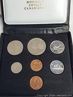 Coins displayed in black velvet presentation box with white lid showing 'Monnaie Royale Canadienne' text.