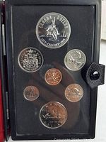 Photo showing the mint sealed set of Canadian coins from 1875-1975 in a black presentation holder.