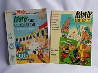 Two Asterix comic books displayed side by side, "Asterix the Gladiator" on the left and "Asterix the Gaul" on the right.