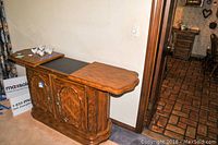 Front view of expandable wooden butler buffet with extended top open.