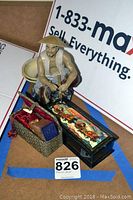 Overview photo showing Asian man figurine with conical hat, carved stamp seal in decorative box, and lacquered rectangular box with painted lid.