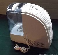 Side angle view showing water tank, power cord wrapped at base and vent grille on side.