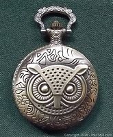 Close-up of the front cover showing the ornate bronze owl face detail on the pocket watch.
