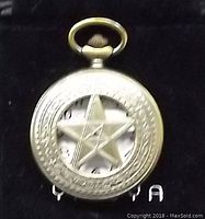 Front cover of the pocket watch showing a bronze pentagram star design with intricate circular patterns.