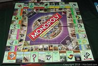 Monopoly World Edition board game showing the full purple game board with properties and electronic banking unit spaces