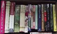 Top down view of 23 assorted books in a box, titles visible including The Paris Wife, The Book of Girl Stuff, Beulah Land