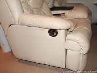 Side view showing beige leather upholstery and reclining lever on armrest