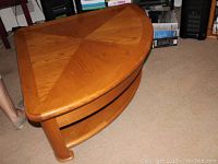 Triangular wooden coffee table with a lift-up top surface showing overall design and structure with storage shelf underneath.