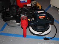 Photo showing Skilsaw circular saw, Ryobi orbital buffer, and Milwaukee hammer drill clustered together on floor, cords visible, all appear lightly used.