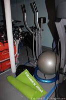 Photo showing Sharper Image air glider, fitness mat, ball, and foot massager in basement setting.