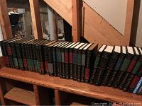 Row of The Great Books volumes 1 to 36 with consistent hardbound black covers and gilt tops