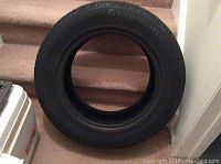 Front view of the Continental tire showing the full round shape and tread pattern, positioned on carpeted stairs.