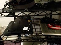 Two laptops on black metal shelf, Samsung Chromebook and HP Mini, untested