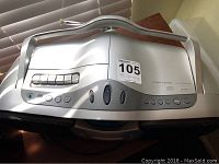 Portable silver CD player with visible buttons and top-loading CD tray