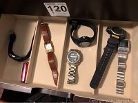 Top drawer view with six watches and a pocket knife