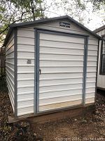 Front view of Morgan metal shed with closed double door on wood skids