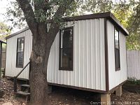 Exterior angled view showing steel siding, windows and wood skids