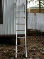 Full view of 16 ft aluminum extension ladder leaning against building