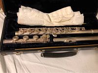 Open hole professional model flute partially assembled in black hard case with cleaning cloth.