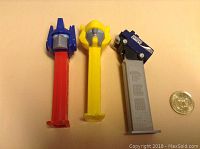 Front view of three PEZ dispensers: Optimus Prime, Bumblebee, Vancouver Canucks themed