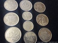 Top-down view of nine circulated Canadian commemorative coins arranged in three columns showing various designs and denominations.