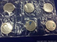 Top side of sealed 2011 Canadian quarters in plastic packaging, showing 6 quarters with visible designs and date 2011.