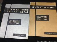 Two jewelry making books on black surface: 'Silversmithing and Art Metal' and 'Jewelry Making' for schools, tradesmen, craftsmen.