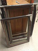 Three old wooden frames stacked inside each other showing considerable wear and chipped paint