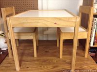 Front view of toddler table and two chairs set on wood floor
