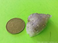 Photo showing one small natural amethyst specimen next to a Canadian coin for scale.