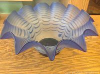 Side view showing the ruffled edge and blue striped pattern on the bowl.