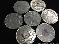 Photo showing seven quarters including Canadian and US coins with various designs such as wildlife, commemorative events, and awareness symbols.
