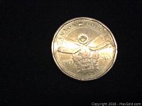 Reverse side of a Canadian loonie coin featuring crossed hockey sticks, a hockey puck and a maple leaf commemorating Toronto Maple Leafs from 1917 to 2013.