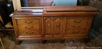Front view of wooden Dixie dresser with 6 drawers and central door, showing overall wear.