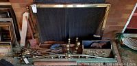 Fireplace tools lying on floor with brass fireplace dogs and metal screen in background