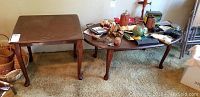 Three wooden tables seen together: one oval coffee table and two smaller accent tables with Queen Anne cabriole legs.